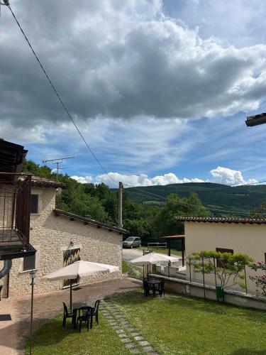 a patio with tables and umbrellas in a yard at Agriturismo Castelfranco - appartamenti Norcia in Norcia