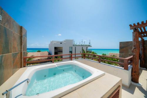 a bath tub on a balcony with a view of the ocean at Beachfront Penthouse with 3 Bedrooms & Ocean View - Las Nubes in Playa del Carmen