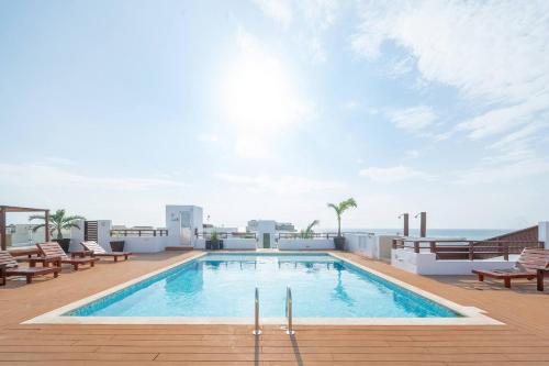 a swimming pool on the roof of a building at Beachfront Penthouse with 3 Bedrooms & Ocean View - Las Nubes in Playa del Carmen