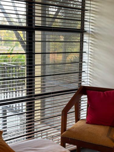 a bedroom with a large window with blinds at Ripples Cove Retreat - Your dream Lakeside getaway in Paravūr
