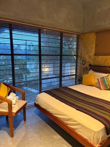 a bedroom with two beds and a large window at Ripples Cove Retreat - Your dream Lakeside getaway in Paravūr