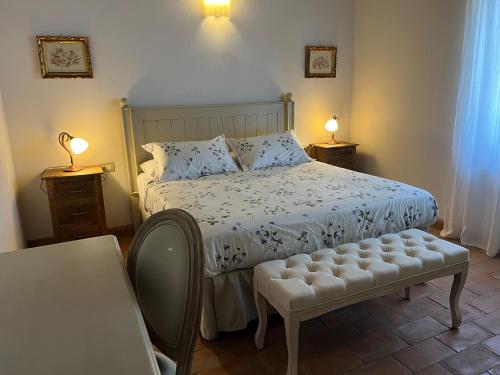 a bedroom with a bed and two tables and two lamps at Podere Le Querce in Montebuono