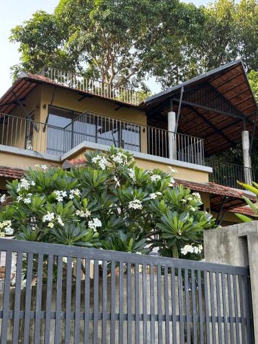 a house with a balcony and a fence at Ripples Cove Retreat - Your dream Lakeside getaway in Paravūr