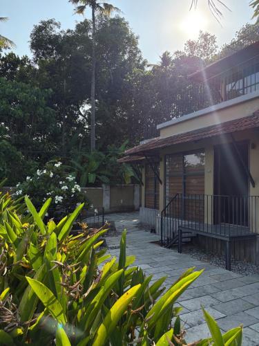 a building with a porch and some plants at Ripples Cove Retreat - Your dream Lakeside getaway in Paravūr