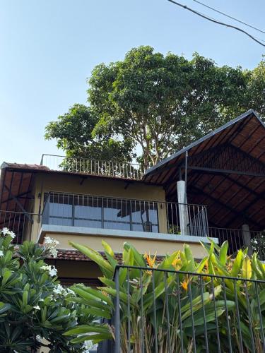 a building with a balcony and trees in the background at Ripples Cove Retreat - Your dream Lakeside getaway in Paravūr
