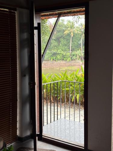 an open door to a balcony with a view at Ripples Cove Retreat - Your dream Lakeside getaway in Paravūr