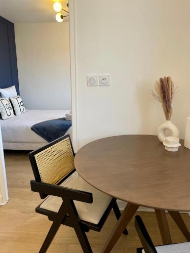Una mesa y una silla en una habitación con una cama. en Appartement Gare 2 Personnes, en Le Mans