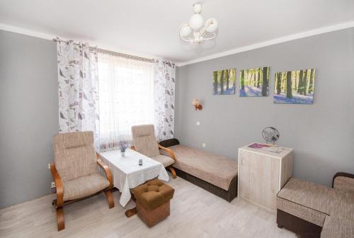 a living room with a table and chairs and a couch at Noclegi Paradise in Darłówko