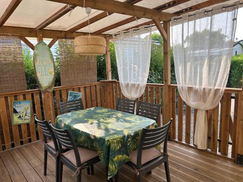 une terrasse en bois avec une table et des chaises dessus dans l'établissement Abina-Eugene, à Saint-Aygulf