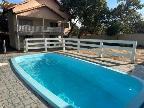 a blue swimming pool in front of a house at Pousada Rio Cipó in Serra do Cipo