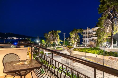 a table with wine glasses on a balcony at night at Kaplanis House in Neos Marmaras