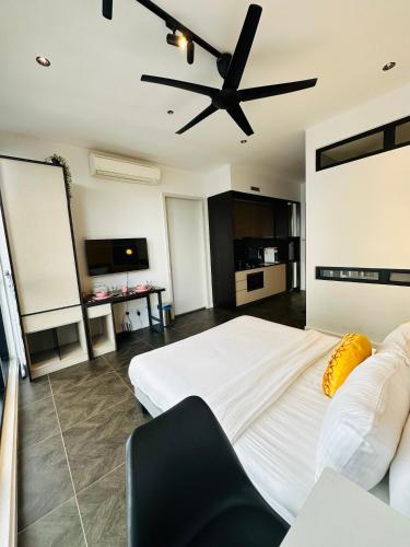 a bedroom with a large bed with a ceiling fan at Scartlez suites KLCC by Dream in Gua Sai