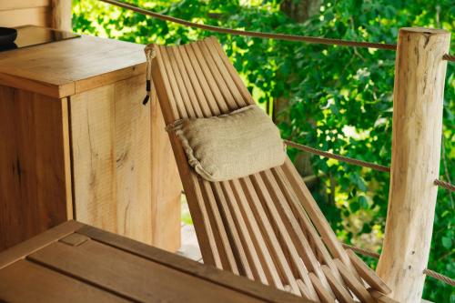 a wooden chair sitting next to a wooden table at Lakeside Glamping Tents Mažijev Grič in Gradišče pri Lukovici