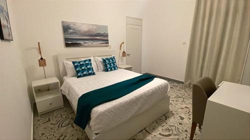a bedroom with a large bed with blue pillows at Hotel Boutique Brisas Colonial in Santo Domingo