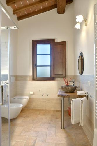 a bathroom with a tub and a toilet and a sink at Podere La Querciola in Guardistallo