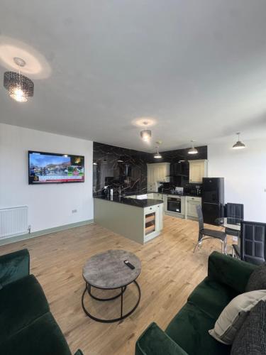 a living room with a couch and a table and a kitchen at CityWest Apartments in Newcastle upon Tyne