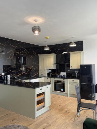 a kitchen with white cabinets and a black wall at CityWest Apartments in Newcastle upon Tyne