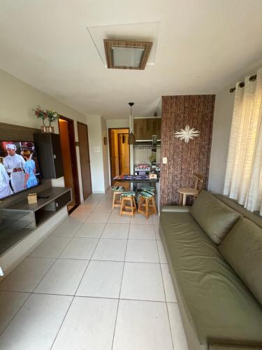 a living room with a green couch and a kitchen at flat em serra negra - bezerros in Bezerros