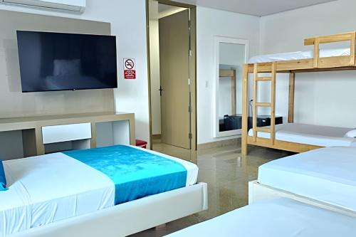 a room with two beds and a flat screen tv at Hotel Lotto Boutique in Cali
