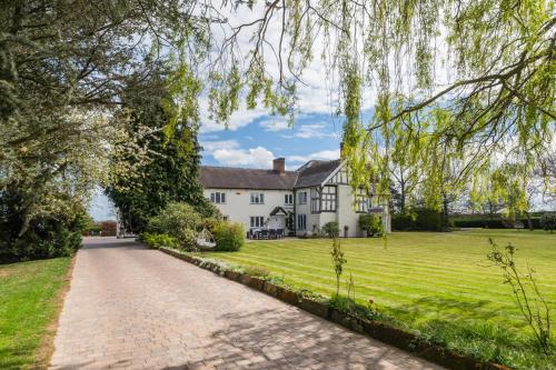 an estate with a large white house with a driveway at Hall O'Coole in Nantwich