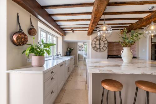a kitchen with white countertops and wooden ceilings at Hall O'Coole in Nantwich