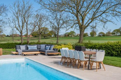 a patio with a table and chairs next to a pool at Hall O'Coole in Nantwich
