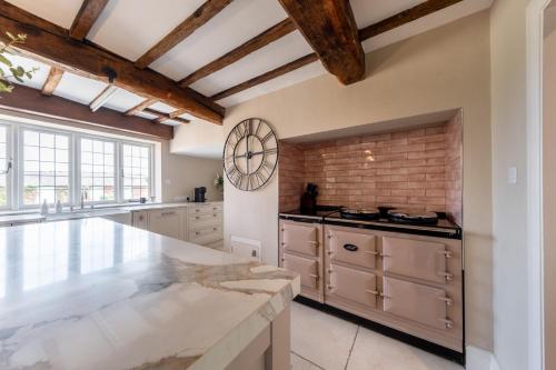a large kitchen with white cabinets and a large counter top at Hall O'Coole in Nantwich