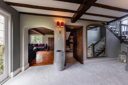 a living room with a vaulted ceiling and a staircase at Hall O'Coole in Nantwich
