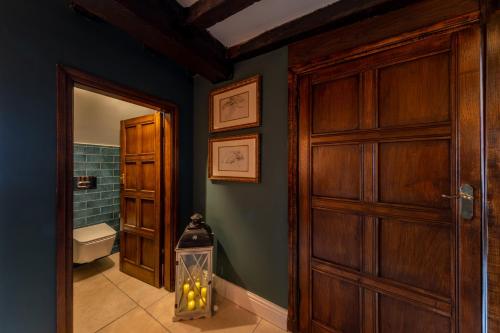 a bathroom with a door and a toilet in a room at Hall O'Coole in Nantwich