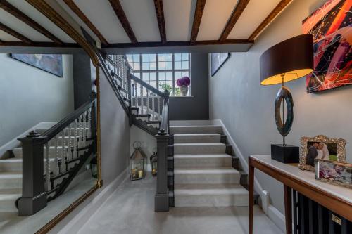 a staircase in a home with blue walls and wooden ceilings at Hall O'Coole in Nantwich