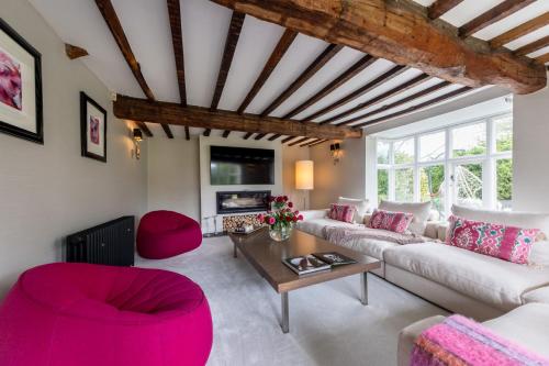 a living room with a white couch and red chairs at Hall O'Coole in Nantwich
