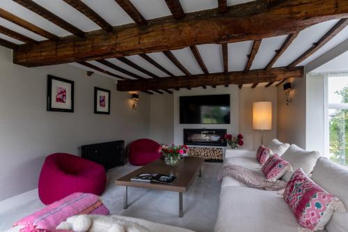 a living room with a white couch and pink chairs at Hall O'Coole in Nantwich