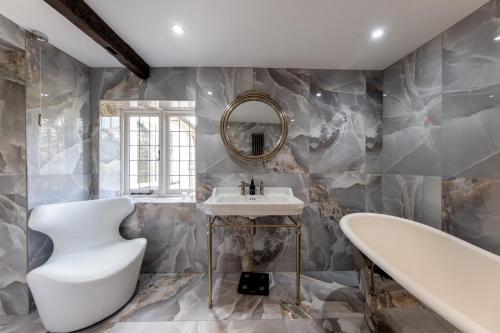 a bathroom with a sink and a tub and a mirror at Hall O'Coole in Nantwich
