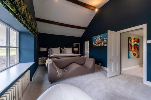 a bedroom with blue walls and a bed and a couch at Hall O'Coole in Nantwich