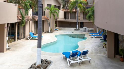 an overhead view of the pool at a hotel with chairs and a palm tree at The Cove Door 15 Main Floor Unit in Ocotal