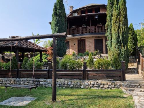 a house with a fence and a swing in a yard at Holiday Home Drinsko svitanje in Gornja Trešnjica