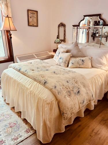a bedroom with a large bed with white sheets at Maison Rose in Hudson