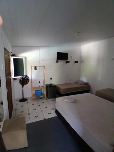 a room with a bed and a television in it at Pousada Unidos in Jijoca de Jericoacoara