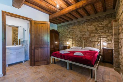 a bedroom with a bed and a stone wall at Podere La Querciola in Guardistallo