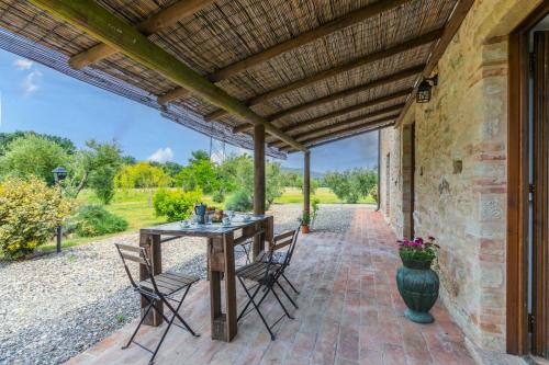 an outdoor patio with a wooden table and chairs at Podere La Querciola in Guardistallo