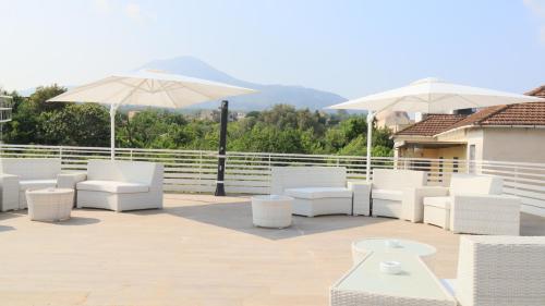 a group of white chairs and umbrellas on a patio at Borgo Alto B&B in Boscotrecase