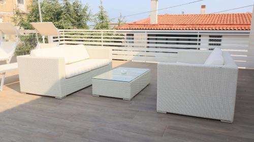 three white chairs and a table on a patio at Borgo Alto B&B in Boscotrecase