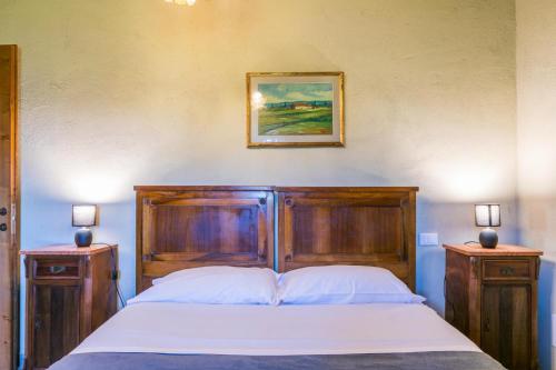 a bedroom with a large wooden bed with two night stands at Podere La Querciola in Guardistallo