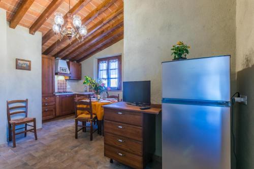 a kitchen with a refrigerator and a dining room at Podere La Querciola in Guardistallo