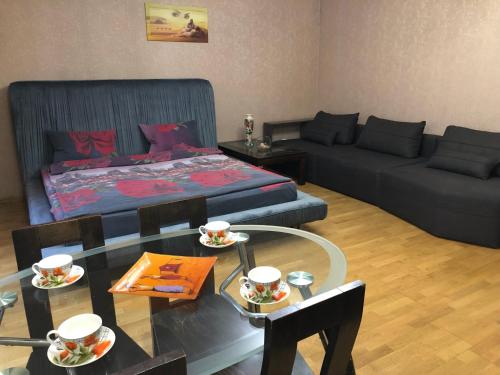 ein Wohnzimmer mit einem Bett und einem Glastisch in der Unterkunft 1 комнатная квартира студио возле ТРЦ Днепроплаза in Tscherkassy