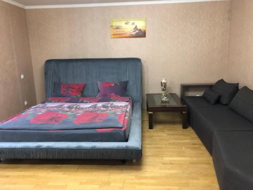 ein Schlafzimmer mit einem Bett und einer Couch in der Unterkunft 1 комнатная квартира студио возле ТРЦ Днепроплаза in Tscherkassy