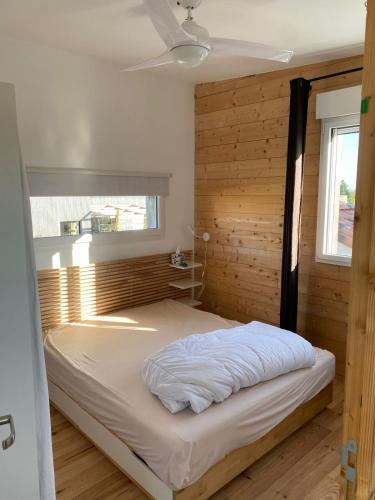 un lit dans une chambre avec un mur en bois dans l'établissement Maison des conches, à Longeville-sur-Mer
