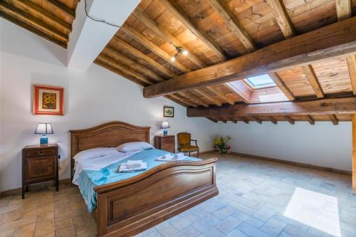a bedroom with a bed and wooden ceilings at Podere La Querciola in Guardistallo