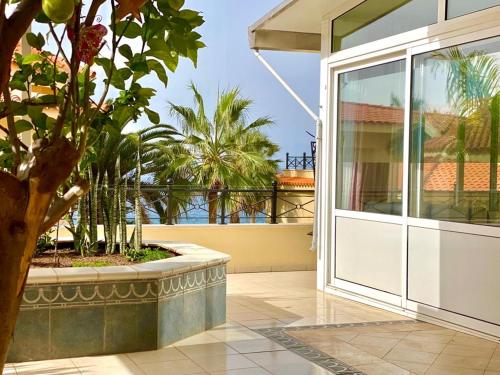 een open deur naar een balkon met palmbomen bij Villa Sol Los Cristianos in Los Cristianos