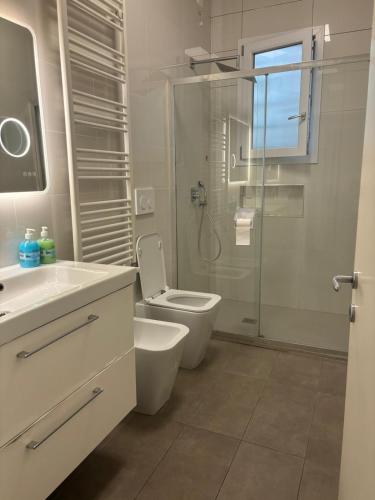 a bathroom with a toilet and a glass shower at Venice Station Guest House in Mestre